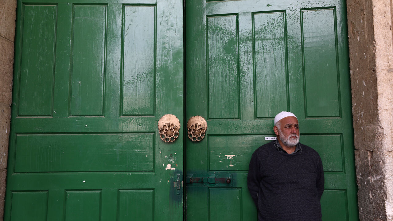 HEALTH-CORONAVIRUS/PALESTINIANS-AL AQSA? An employee of the Islamic Waqf stands in front of the closed doors of Al-Aqsa mosque in the compound known to Muslims as Noble Sanctuary and to Jews as Temple Mount in Jerusalem's Old City, after Muslim clerics shut the mosque until further notice as a precaution against coronavirus March 15, 2020. REUTERS/Ammar Awad - RC2BKF9DQLY0