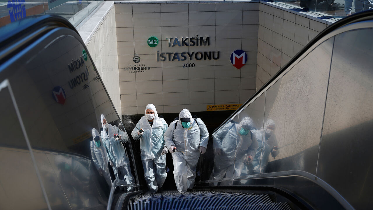 HEALTH-CORONAVIRUS/TURKEY Municipality workers in protective suits disinfect entrance of Taksim metro station in central Istanbul, Turkey, March 17, 2020. REUTERS/Kemal Aslan - RC2ULF95LNH1
