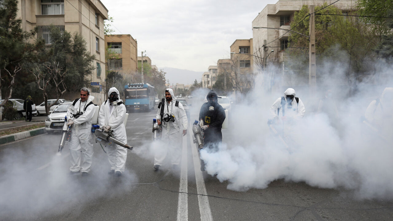 HEALTH-CORONAVIRUS/IRAN-NOWRUZ Members of firefighters wear protective face masks, amid fear of coronavirus disease (COVID-19), as they disinfect the streets, ahead of the Iranian New Year Nowruz, March 20, in Tehran, Iran March 18, 2020. Picture taken March 18, 2020. WANA (West Asia News Agency)/Ali Khara via REUTERS ATTENTION EDITORS - THIS PICTURE WAS PROVIDED BY A THIRD PARTY TPX IMAGES OF THE DAY - RC23NF9FQH2G