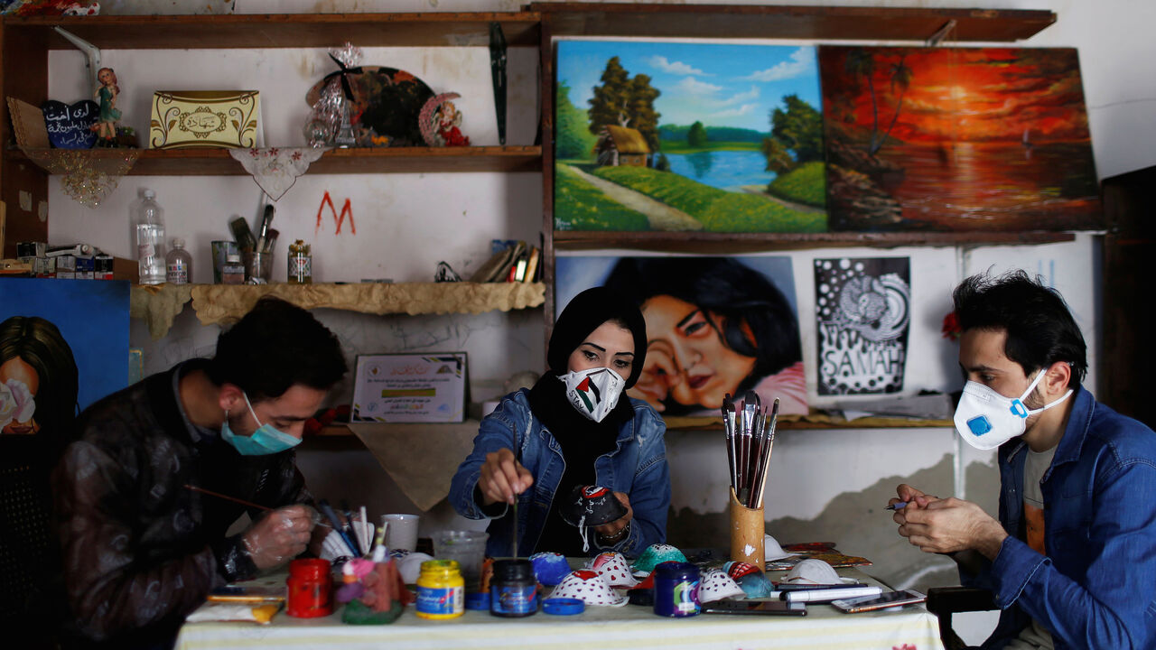 HEALTH-CORONAVIRUS/PALESTINIANS-MASKS Palestinian artists paint protective face masks to encourage people to wear them as a precaution against the coronavirus disease (COVID-19), in Gaza City March 30, 2020. REUTERS/Mohammed Salem - RC2DUF9EIP84