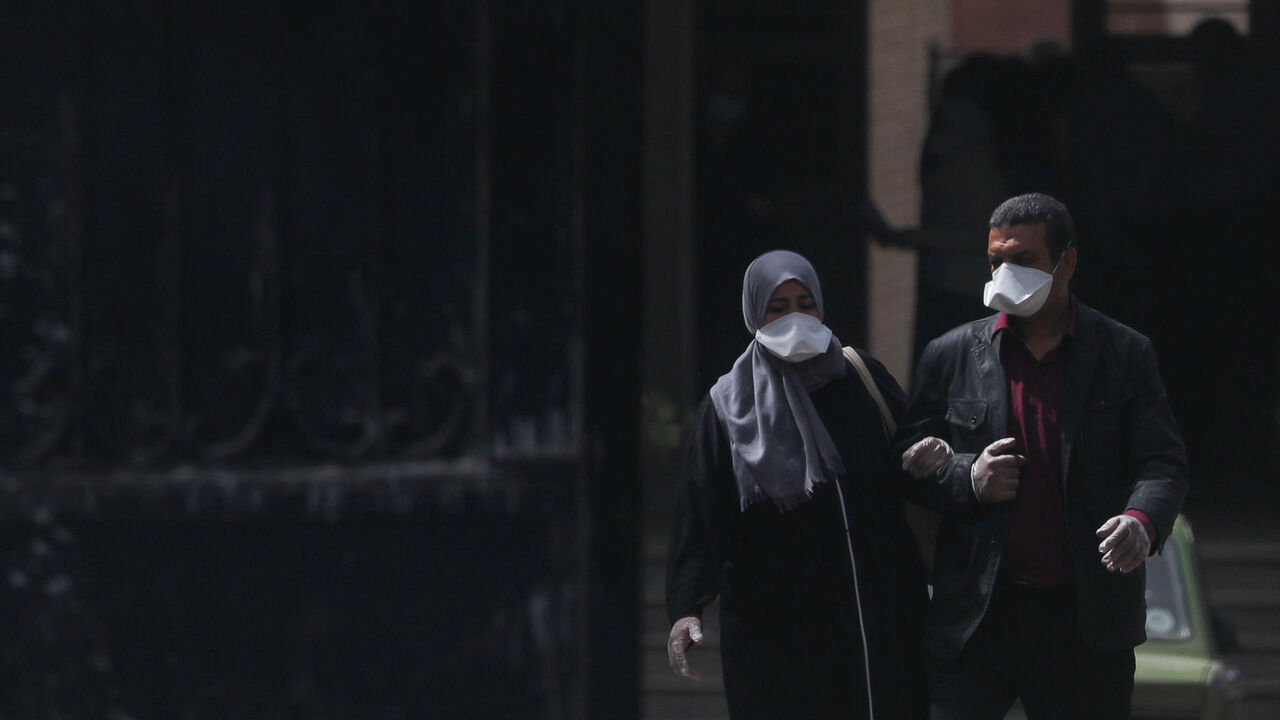 HEALTH-CORONAVIRUS/EGYPT A man and a woman wear protective masks amid concerns over the coronavirus disease (COVID-19) as they walk from the main gate of a hospital in Cairo, Egypt March 31, 2020. REUTERS/Amr Abdallah Dalsh - RC26VF98YX8F