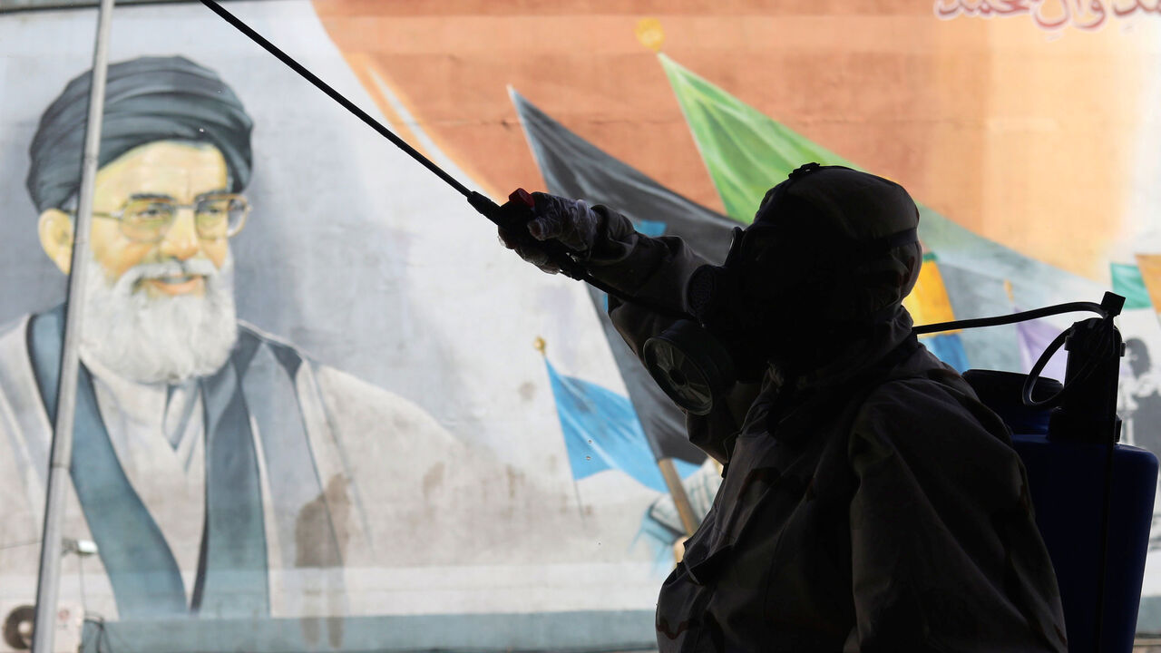 HEALTH-CORONAVIRUS/IRAN A volunteer from Basij forces wearing a protective suit and face mask sprays disinfectant as he sanitizes a bus station, amid the coronavirus disease (COVID-19) fears, in Tehran, Iran April 3, 2020. WANA (West Asia News Agency)/Ali Khara via REUTERS ATTENTION EDITORS - THIS PICTURE WAS PROVIDED BY A THIRD PARTY - RC2YWF9PA44V