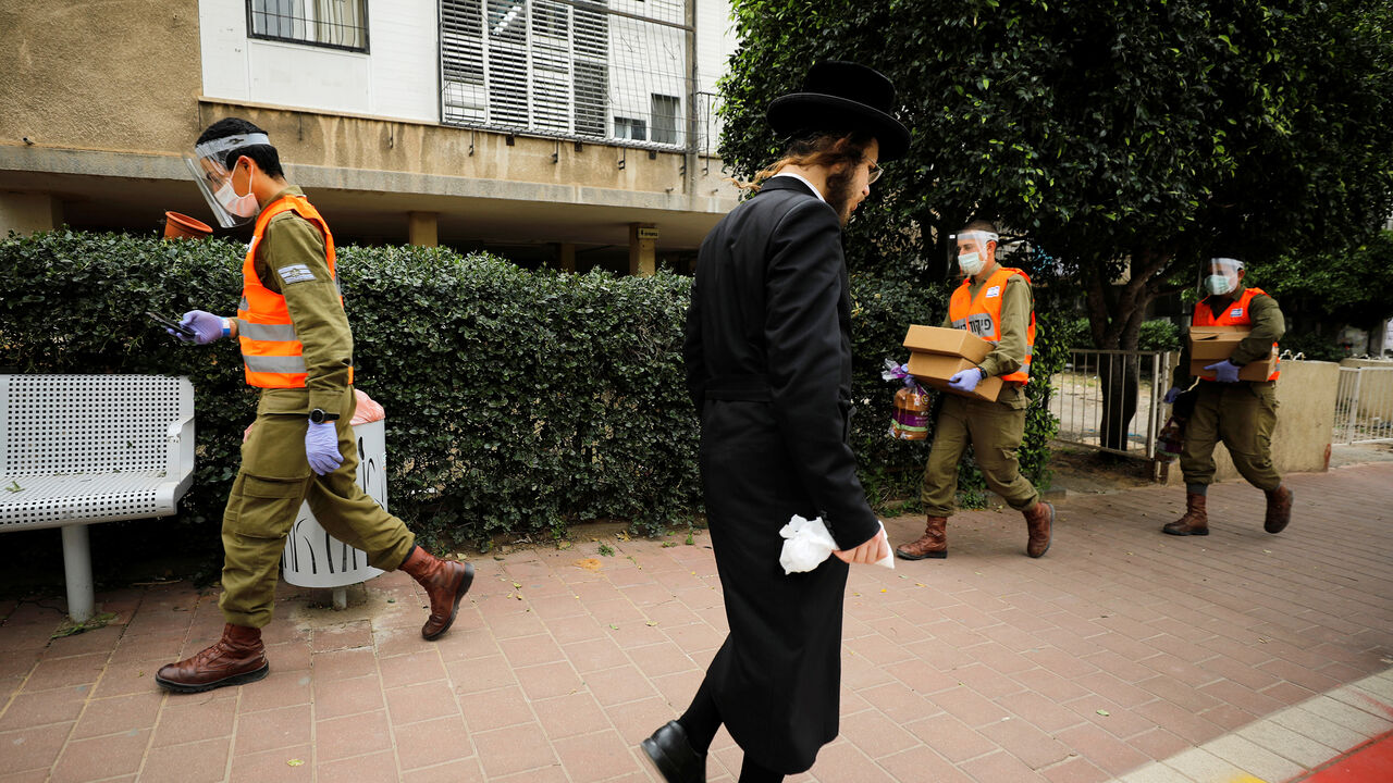 HEALTH-CORONAVIRUS/ISRAEL-ULTRAORTHODOX Israeli soldiers deliver food to residents in Bnei Brak, an ultra-Orthodox Jewish town badly affected by the coronavirus disease (COVID-19), and which Israel declared a "restricted zone" due to its high rate of infections, near Tel Aviv, Israel April 5, 2020. REUTERS/Amir Cohen - RC2BYF9AZODO