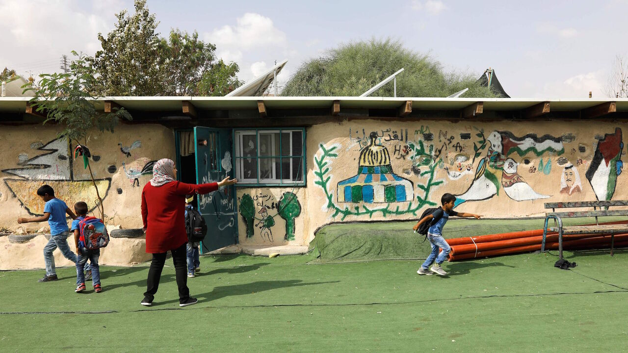 1052672976 Palestinian Bedouin schoolchildren play in the yard of their school in the Palestinian Bedouin village of Khan al-Ahmar, east of Jerusalem, in the occupied West Bank, on October 21, 2018. - Israeli Prime Minister Benjamin Netanyahu has frozen plans to demolish a strategically located Bedouin village in the occupied West Bank that has drawn the world's attention, his office said on October 21. "The intention is to give a chance to the negotiations and the offers we received from different bodies, including i