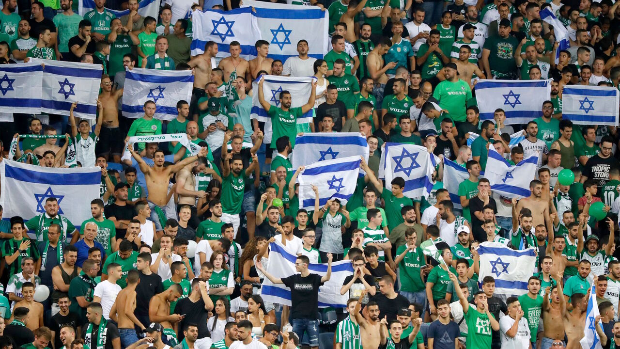 1158934993 Maccabi fans cheer for their team prior to the second leg of the Europa league second round qualifier football match between Maccabi Haifa and RC Strasbourg at the Sammy Hofer stadium in Haifa on August 1, 2019. (Photo by Jack GUEZ / AFP) (Photo credit should read JACK GUEZ/AFP via Getty Images)