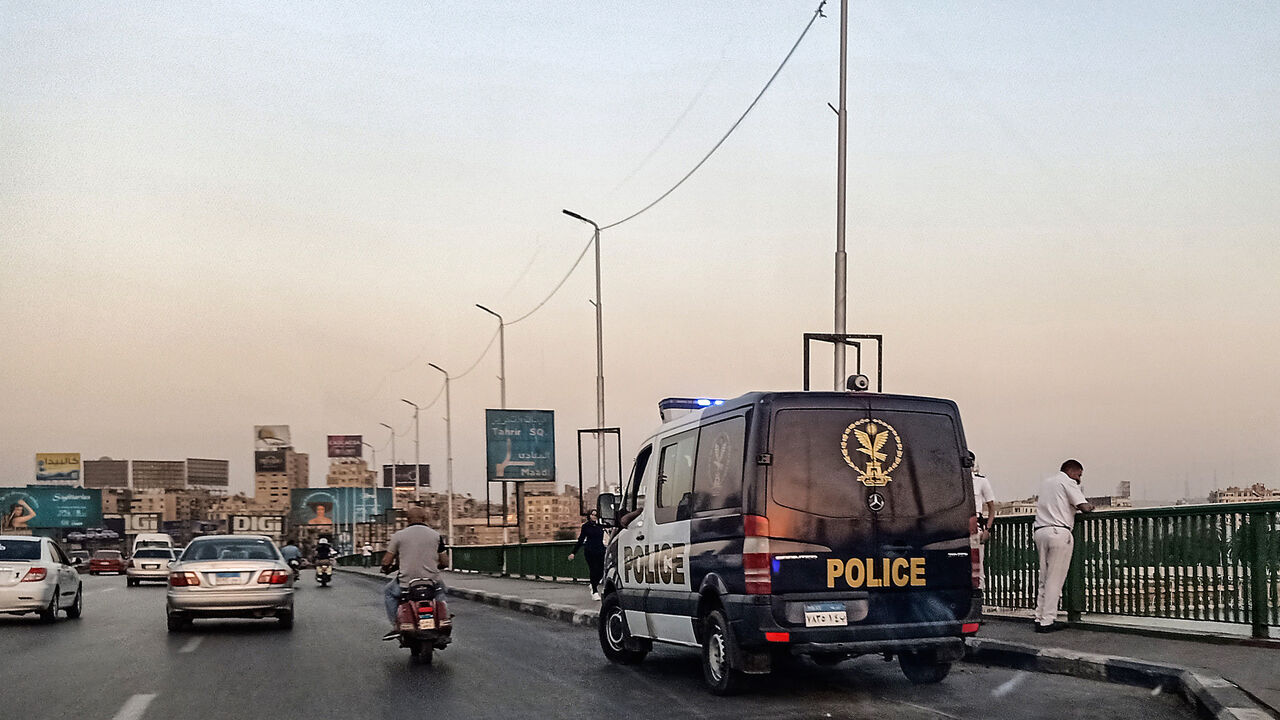 1170047189 Policemen stand next to a patrol car parked along the 6th of October bridge crossing the Nile in the centre of the Egyptian capital Cairo on September 21, 2019. - Protests erupted late on September 20 in Cairo and other Egyptian cities calling for the removal of President Abdel Fattah al-Sisi, in a rare show of dissent quickly quashed by authorities. After overnight clashes with the protesters, security forces the following day maintained tight control of Tahrir Square -- the epicentre of the 2011 revolutio