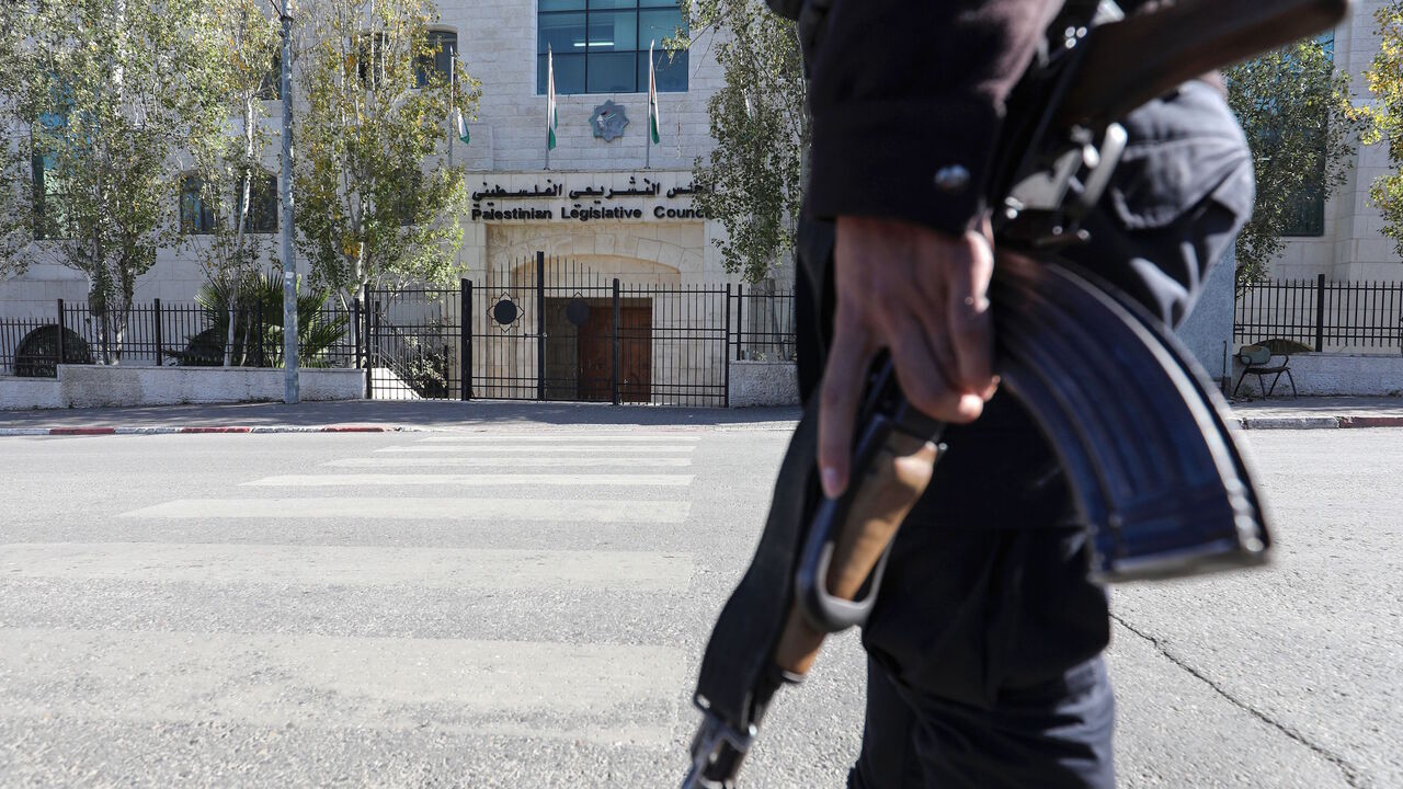 1193579557 Palestinian police stand guard near the main door of the defunct Palestinian Parliament in the West Bank city of Ramallah on December 17, 2019. - It has been more than a decade since the Palestinian Legislative Council (PLC) last met in Ramallah, due to infighting between Palestinian president Mahmud Abbas's Fatah and Islamists Hamas. The shiny new parliament building was opened in 2004 in central Ramallah, the Palestinian city in the occupied West Bank 10 miles (16 kilometres) north of Jerusalem. Construct