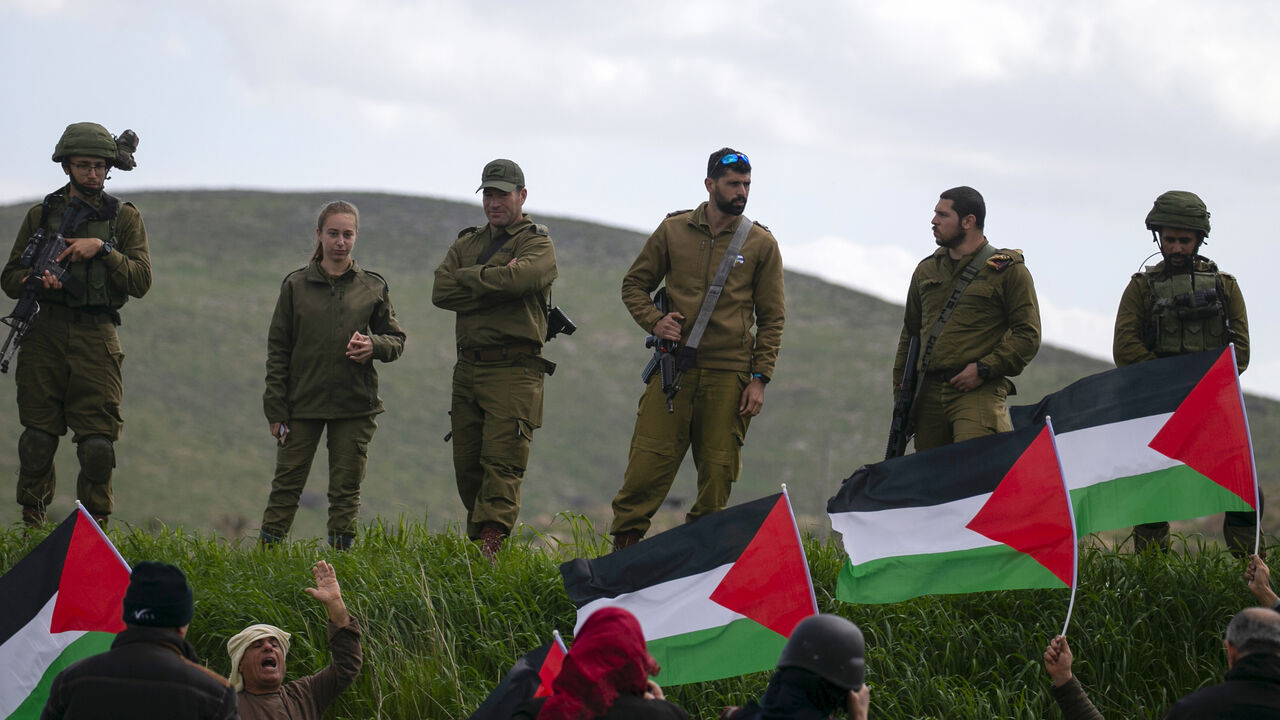 1204139974 Israeli soldiers stand at attention as Palestinian demonstrators take part in a protest against the annexation of the Jordan Valley, in the village of Tammun, east of West Bank village of Tubas, near the Jordan Valley, on February 29, 2020. (Photo by JAAFAR ASHTIYEH / AFP) (Photo by JAAFAR ASHTIYEH/AFP via Getty Images)