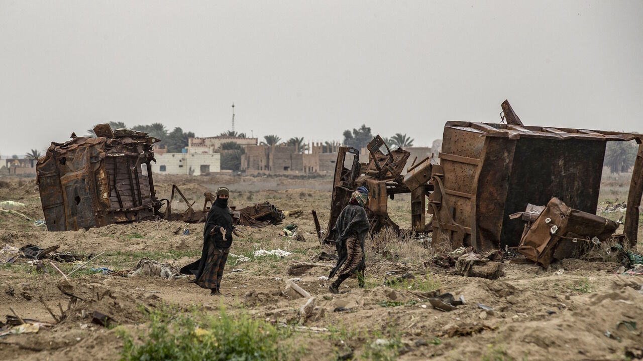 1207684674 TOPSHOT - Relatives of farmer Hamad al-Ibrahim clean his damaged land in the eastern Syrian village of Baghouz on March 13, 2020, a year after the fall of the Islamic State's (IS) caliphate. - A year after the last black flag of the Islamic State group was lowered in the Syrian village of Baghouz, traces of the jihadist group are still all around this small and remote village near the Iraqi border, where Kurdish fighters and the US-led coalition declared the IS proto-state defeated in March 2019 after a bli