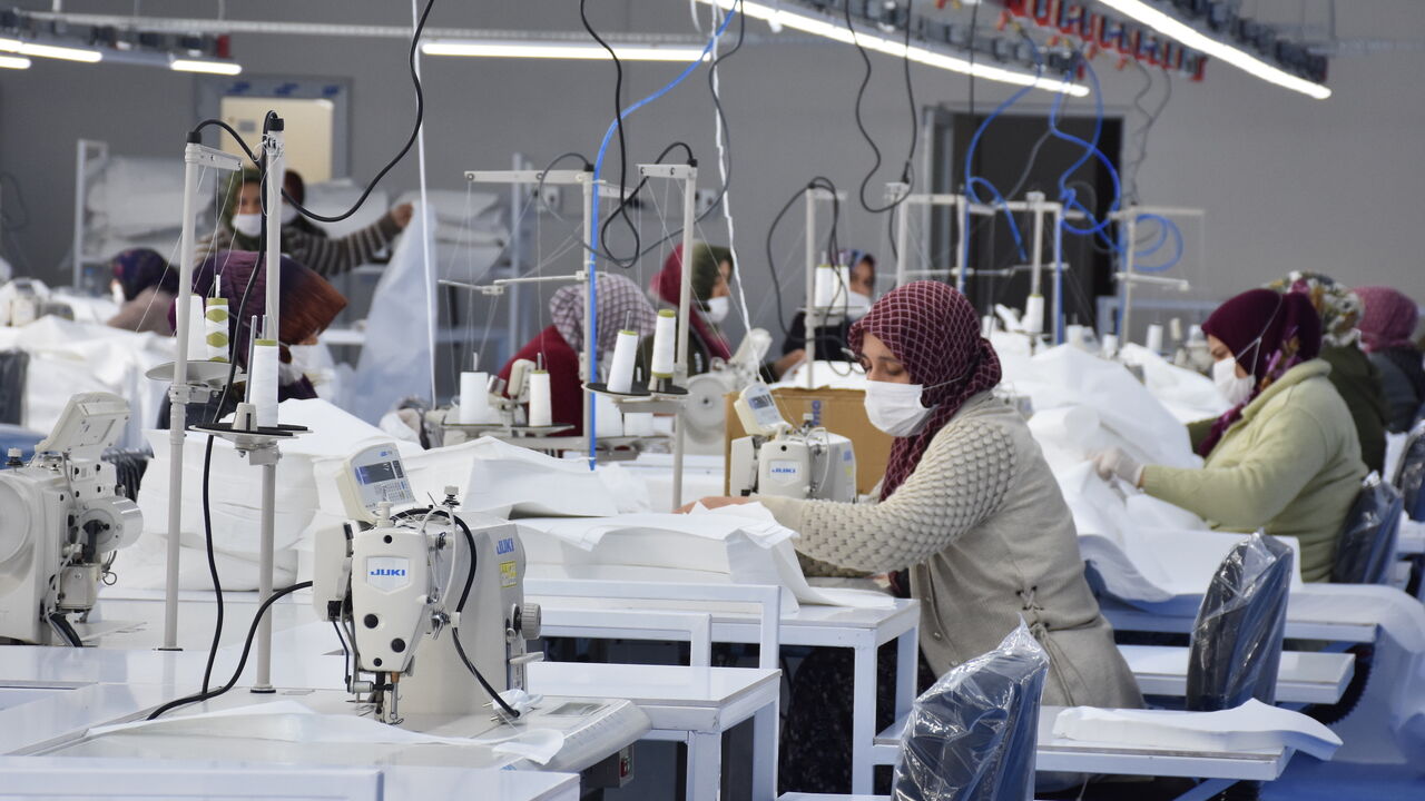 1209156437 AFYONKARAHISAR, TURKEY - MARCH 31: Textile workers wearing face masks laboring at a textile factory turned into medical suits production plant due to the coronavirus (COVID-19) pandemic in Afyonkarahisar, Turkey on March 31, 2020. (Photo by Canan Tukelay/Anadolu Agency via Getty Images)
