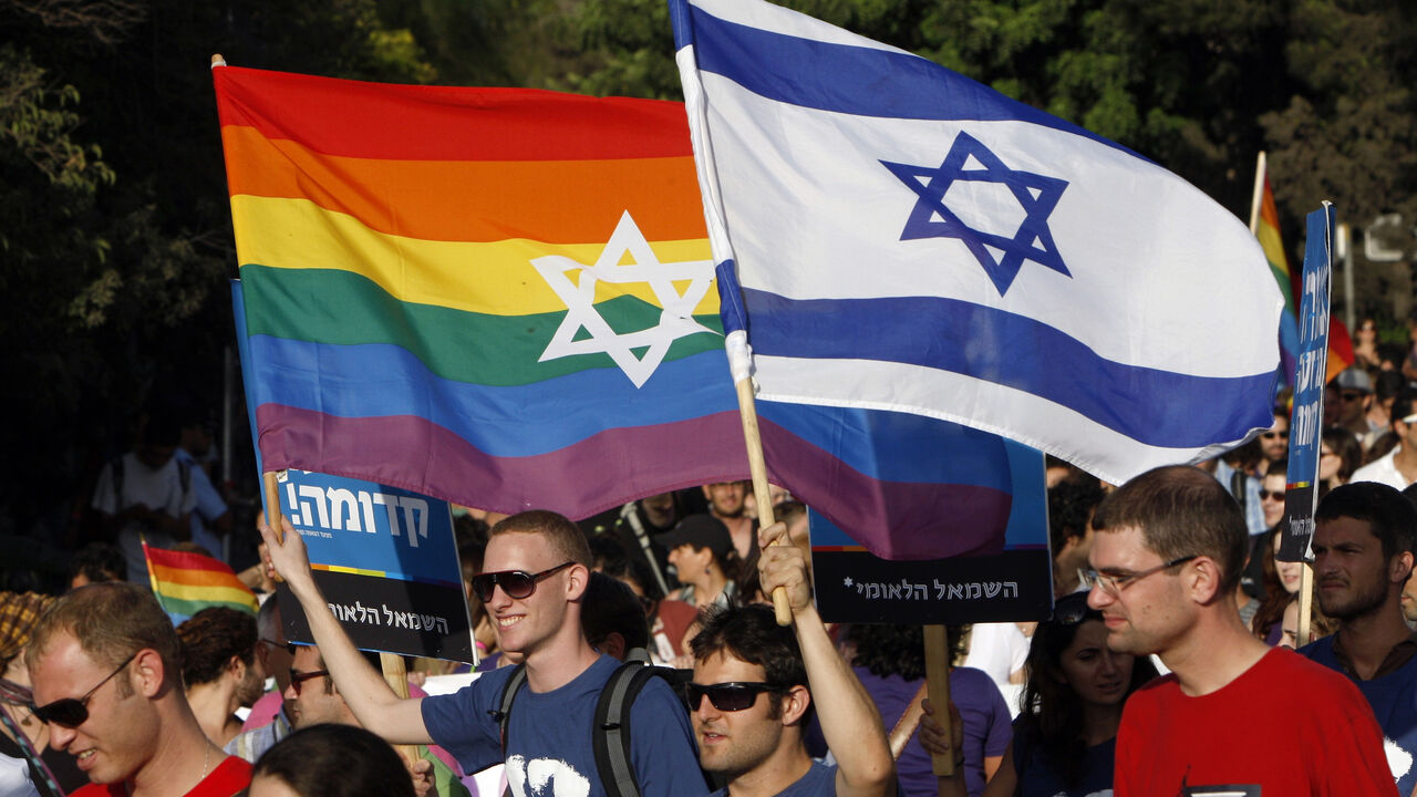ISRAEL/ Participants hold flags during the gay pride parade in Jerusalem July 29, 2010. This year's parade marks the one-year anniversary of a shooting attack in a gay and lesbian youth center in Tel Aviv, in which two people were killed and 13 were injured. REUTERS/Ronen Zvulun (JERUSALEM - Tags: POLITICS SOCIETY) - GM1E67U04VD01