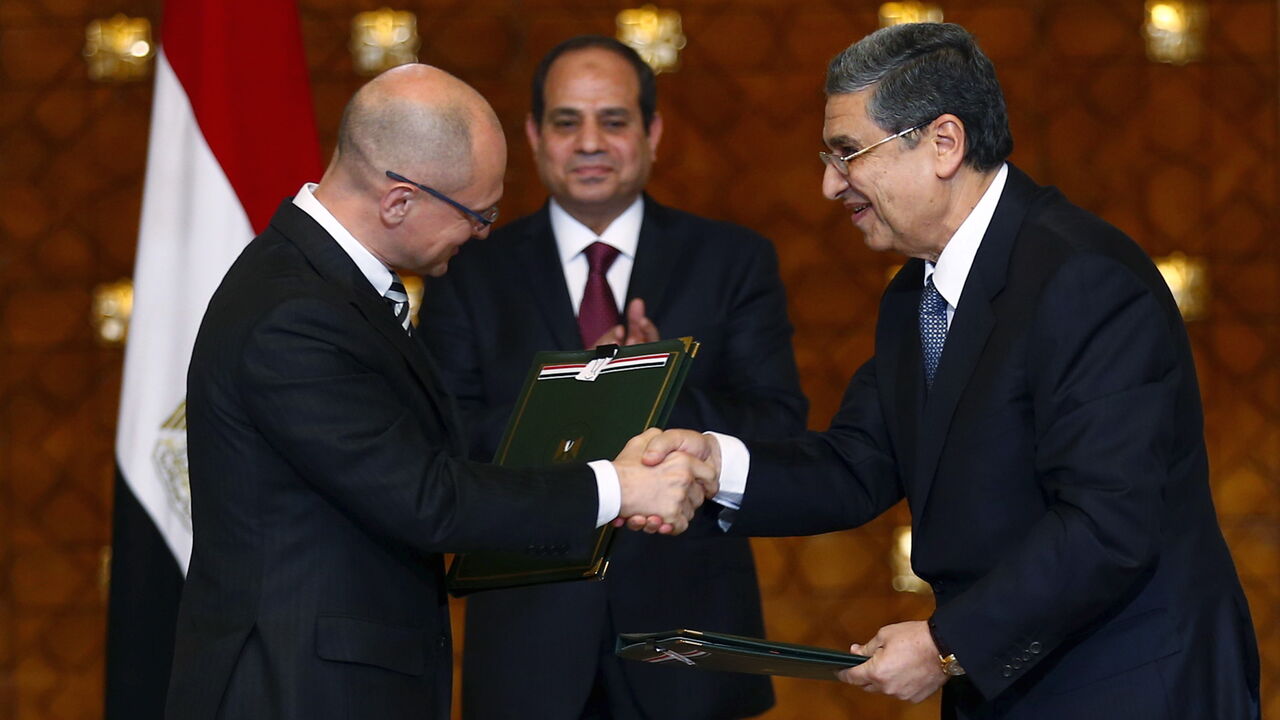 Egypt's President Abdel Fattah al-Sisi (C) looks on as Chief Executive Officer of Russian Rosatom company Sergey Kiriyenko (L) and Egyptian Minister of Electricity and Renewable Energy Mohamed Shaker (R) shakes hand after signing documents for a deal to build Egypt's first nuclear power plant at the Ittihadiya presidential palace in Cairo, Egypt, November 19, 2015. Moscow and Cairo signed an agreement on Thursday for Russia to build a nuclear power plant in Egypt, with Russia extending a loan to Egypt to co