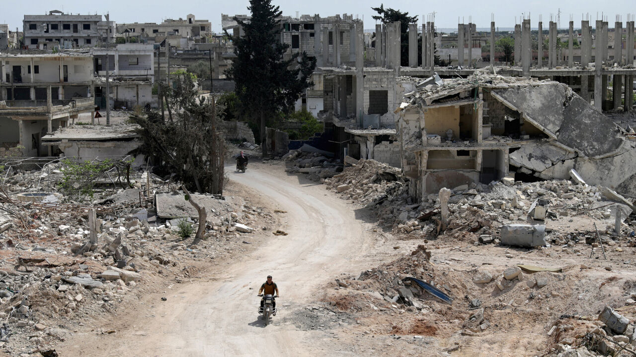 A man rides a motorbike past damaged buildings in the rebel-held town of Nairab, Idlib region, Syria April 17, 2020. Picture taken April 17, 2020.  REUTERS/Khalil Ashawi - RC2C8G9K3BBG