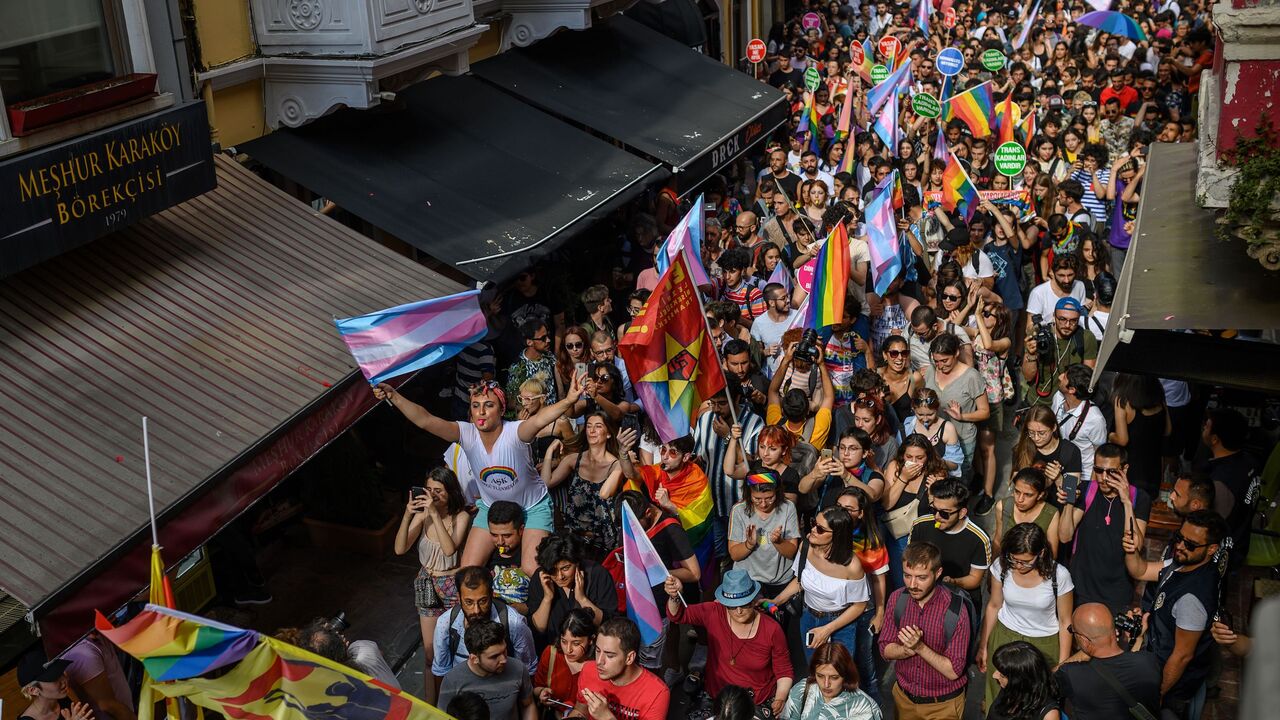 1152949220 Members of the LGBTQ+ community wave flags as they participate in a march during the Gay Pride parade in Istanbul, on June 30, 2019. - Turkish police on June 30 fired tear gas at gay rights groups and activists who defied authorities to march for the Istanbul pride parade, banned for the fifth year in a row. Thousands of people rallied close to the popular Istiklal Avenue and Taksim Square where organisers originally planned to hold the parade, an AFP correspondent said. (Photo by BULENT KILIC / AFP)