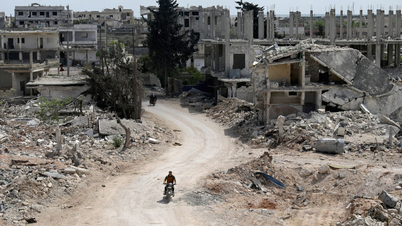 A man rides a motorbike past damaged buildings in the rebel-held town of Nairab, Idlib region, Syria April 17, 2020. Picture taken April 17, 2020.  REUTERS/Khalil Ashawi - RC2C8G9K3BBG