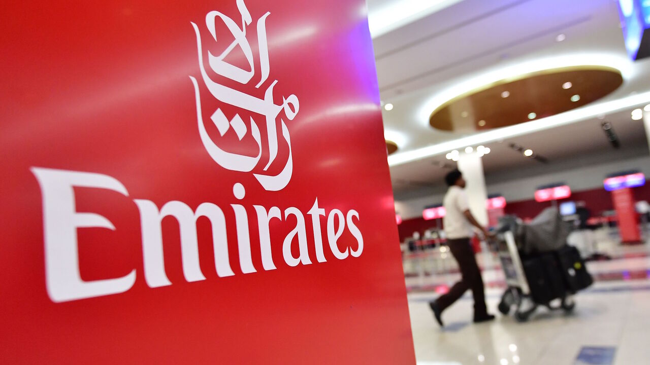 1048781118 A passenger walks past an Emirates airlines logo at Dubai International Airport's T3 in the United Arab Emirates on October 10, 2018. - (Photo by GIUSEPPE CACACE / AFP) (Photo credit should read GIUSEPPE CACACE/AFP via Getty Images)