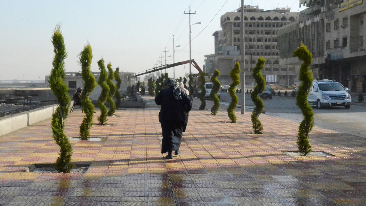 1086991068 A woman walks in between newly planted trees in Iraq's northern city of Mosul, on January 23, 2019, as the war-ravaged city gets a facelift following three years of brutal rule by the Islamic State group. (Photo by Zaid AL-OBEIDI / AFP) (Photo credit should read ZAID AL-OBEIDI/AFP via Getty Images)