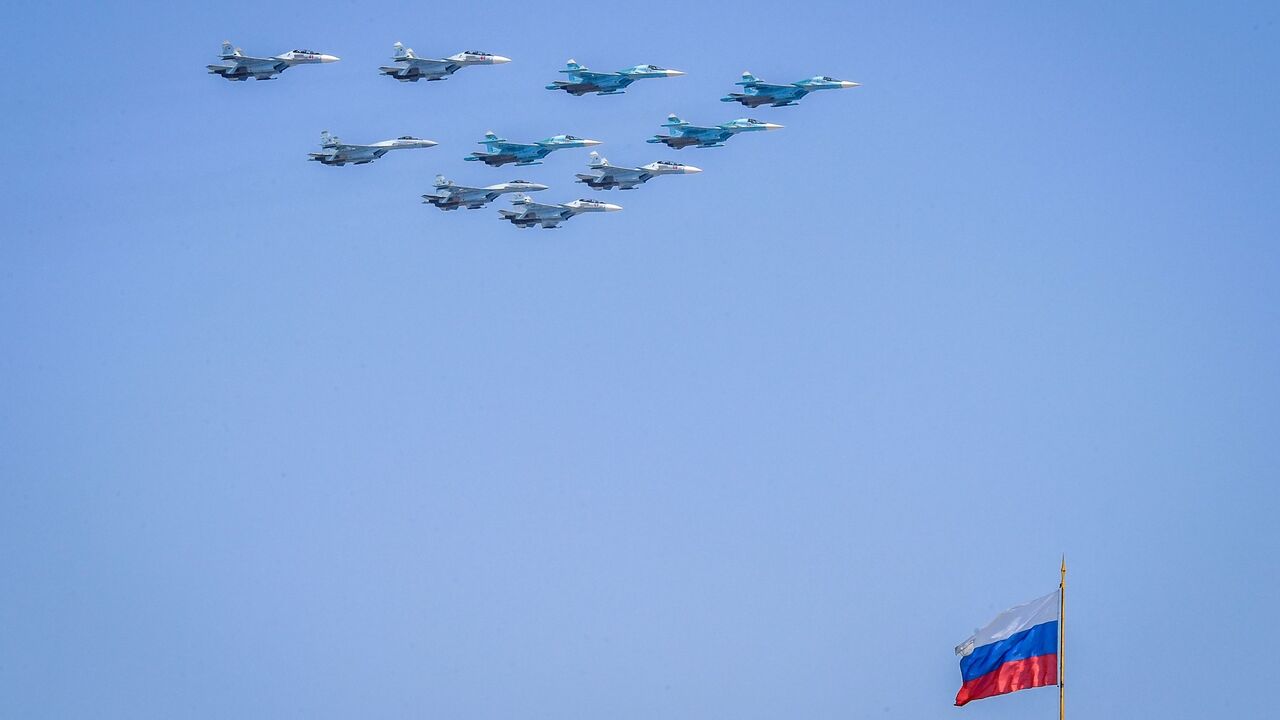 1141871343 TOPSHOT - Russian Sukhoi Su-35 and Su-34 military aircrafts fly over the Russian national flag on the Kremlin palace in Moscow on May 7, 2019, during a rehearsal for the Victory Day military parade. - Russia will celebrate the 74th anniversary of the 1945 victory over Nazi Germany on May 9. (Photo by Yuri KADOBNOV / AFP) (Photo credit should read YURI KADOBNOV/AFP via Getty Images)