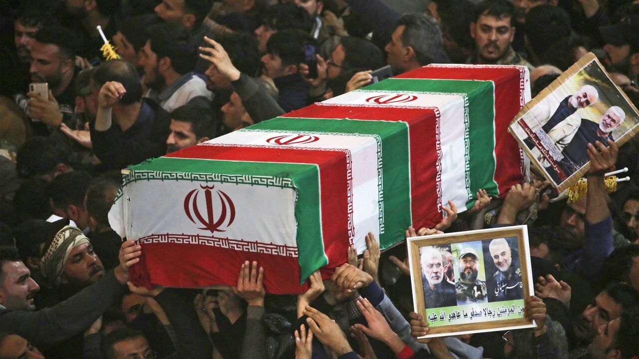 1191712299 TOPSHOT - Mourners carry the coffins of slain Iraqi paramilitary chief Abu Mahdi al-Muhandis, Iranian military commander Qasem Soleimani and eight others inside the Shrine of Imam Hussein in the holy Iraqi city of Karbala,during a funeral procession on January 4, 2020. - Thousands of Iraqis chanting "Death to America" today as they mourned an Iranian commander and others killed in a US drone attack that sparked fears of a regional proxy war between Washington and Tehran. (Photo by Mohammed SAWAF / AFP) (Pho