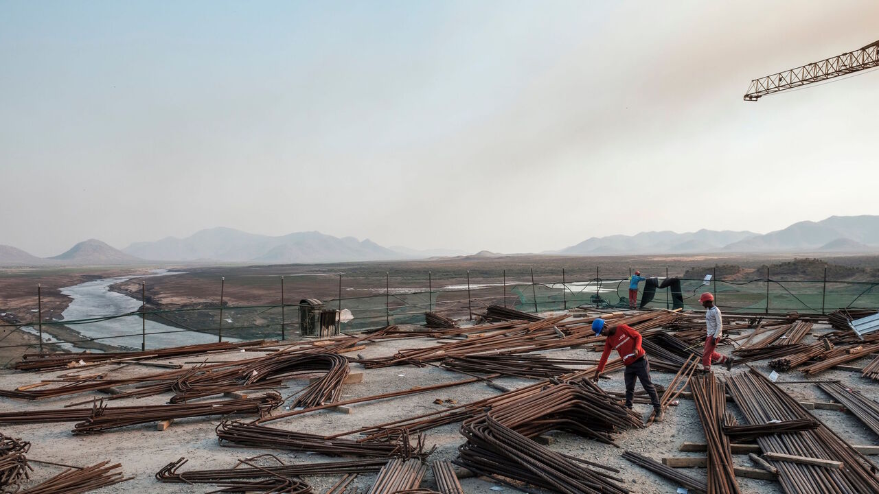 1192325317 Kafule Yigzaw (L) check iron bars at the Grand Ethiopian Renaissance Dam (GERD), near Guba in Ethiopia, on December 26, 2019. - The Grand Ethiopian Renaissance Dam, a 145-metre-high, 1.8-kilometre-long concrete colossus is set to become the largest hydropower plant in Africa.
Across Ethiopia, poor farmers and rich businessmen alike eagerly await the more than 6,000 megawatts of electricity officials say it will ultimately provide.
Yet as thousands of workers toil day and night to finish the project, Ethiop