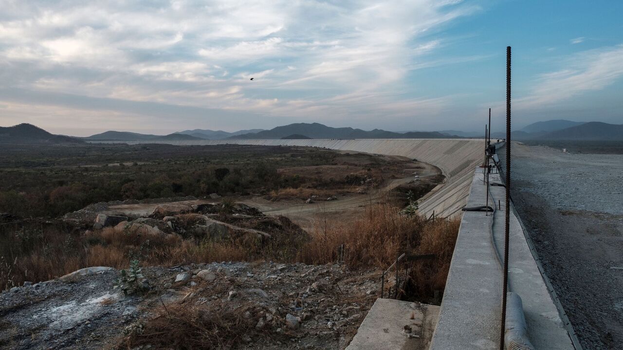 1192325443 A general view of the Saddle Dam, part of the Grand Ethiopian Renaissance Dam (GERD), Ethiopia, near Guba in Ethiopia, on December 26, 2019. - The Grand Ethiopian Renaissance Dam, a 145-metre-high, 1.8-kilometre-long concrete colossus is set to become the largest hydropower plant in Africa.
Across Ethiopia, poor farmers and rich businessmen alike eagerly await the more than 6,000 megawatts of electricity officials say it will ultimately provide.
Yet as thousands of workers toil day and night to finish the