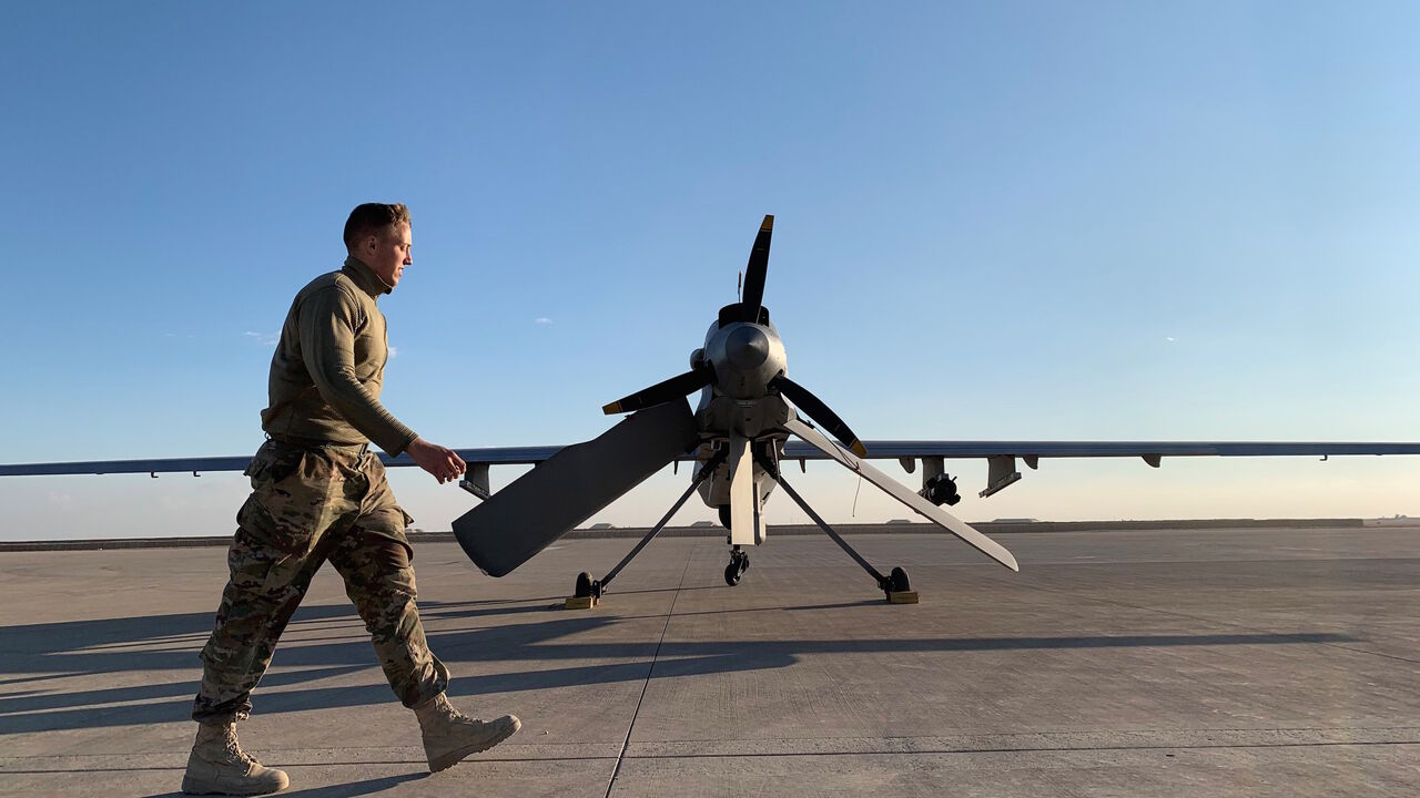 1193596168 A picture taken on January 13, 2020, during a press tour organised by the US-led coalition fighting the remnants of the Islamic State group, shows a member the US forces walking past a drone in the Ain al-Asad airbase in the western Iraqi province of Anbar. - Iran last week launched a wave of missiles at the sprawling Ain al-Asad airbase in western Iraq and a base in Arbil, capital of Iraq's autonomous Kurdish region, both hosting US and other foreign troops, in an operation it dubbed a response to the kill