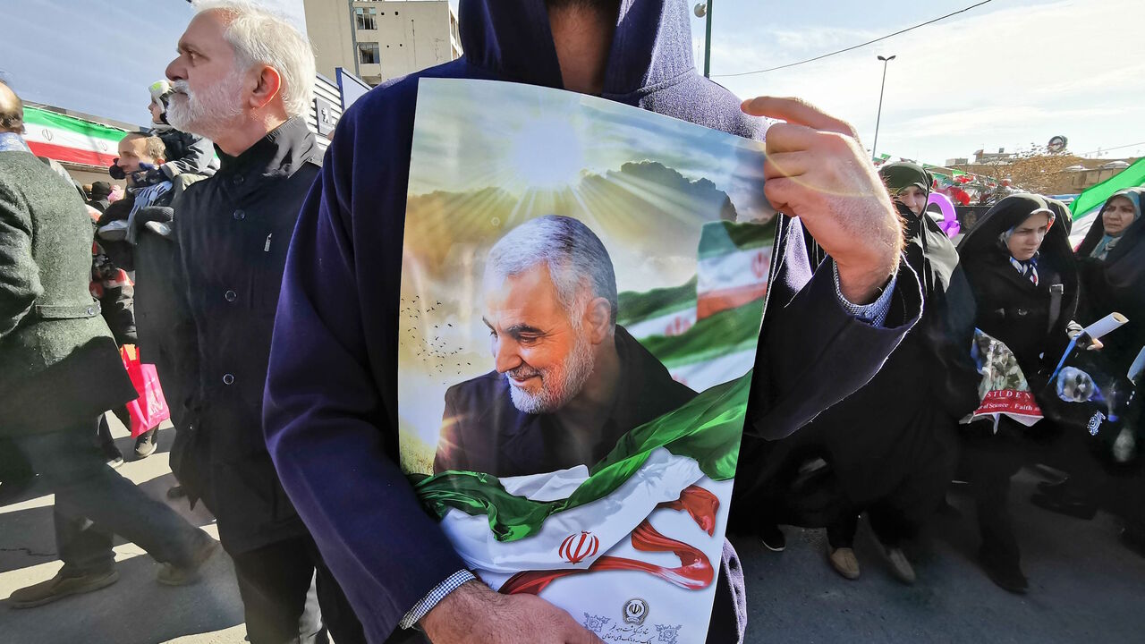 1199972891 A Iranian man carries a portrait of slain Iranian General Qasem Soleimani, on the 40th day of his killing in a US drone strike, during commemorations marking 41 years since the Islamic Revolution, in the capital Tehran on February 11, 2020. - Thousands of Iranians massed for commemorations marking 41 years since the Islamic Revolution, in a show of unity at a time of heightened tensions with the United States. The celebrations mark the day that Shiite cleric Khomeini returned from exile and ousted the shah'