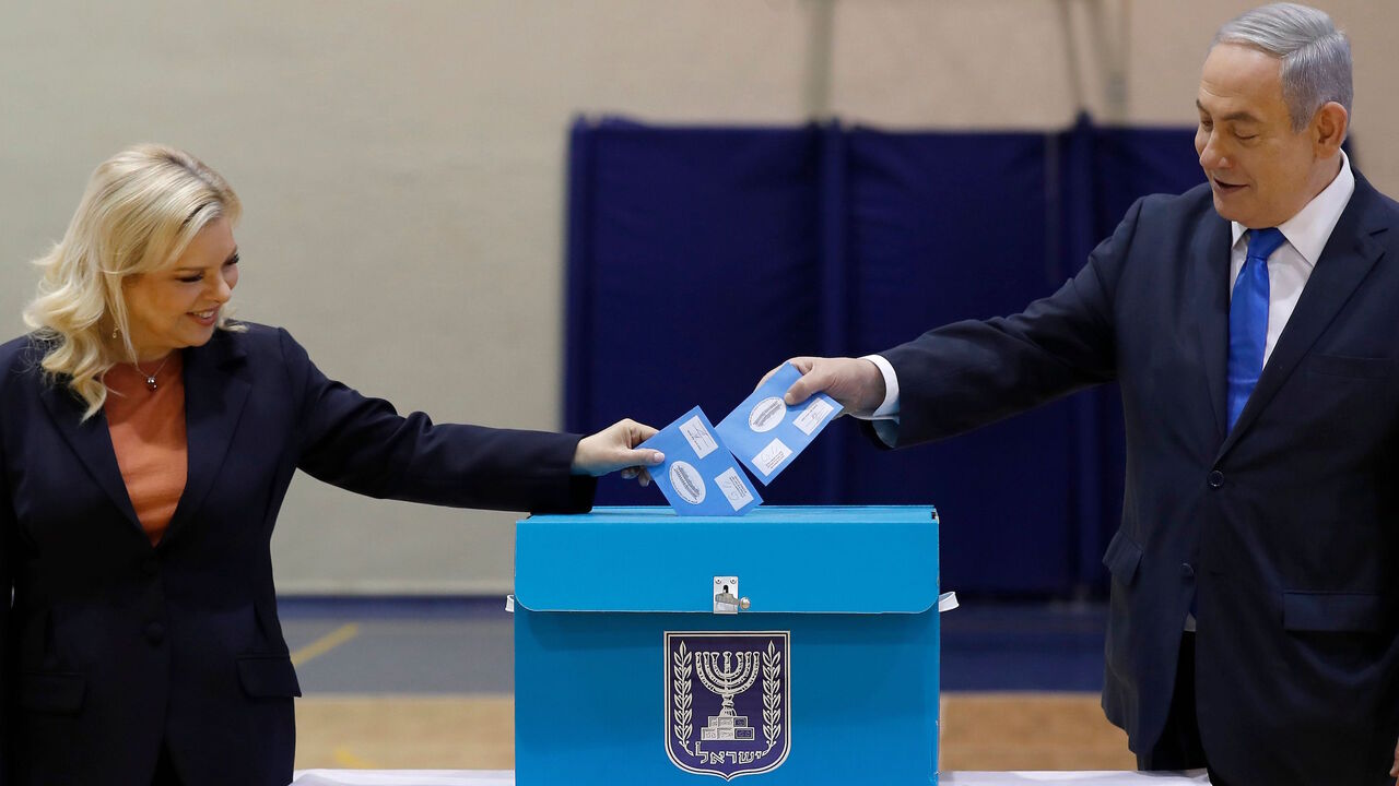 1204593318 Israeli Prime Minister Benjamin Netanyahu (R) and his wife Sara Netanyahu cast their ballots during the Israeli legislative elections, at a polling station in Jerusalem on March 2, 2020. - Netanyahu urged people to vote despite widespread concerns about the coronavirus outbreak, as the longest-serving leader in the Jewish state's history cast his ballot. Israelis were voting for a third time in 12 months today, with embattled Prime Minister Benjamin Netanyahu seeking to end the country's political crisis an
