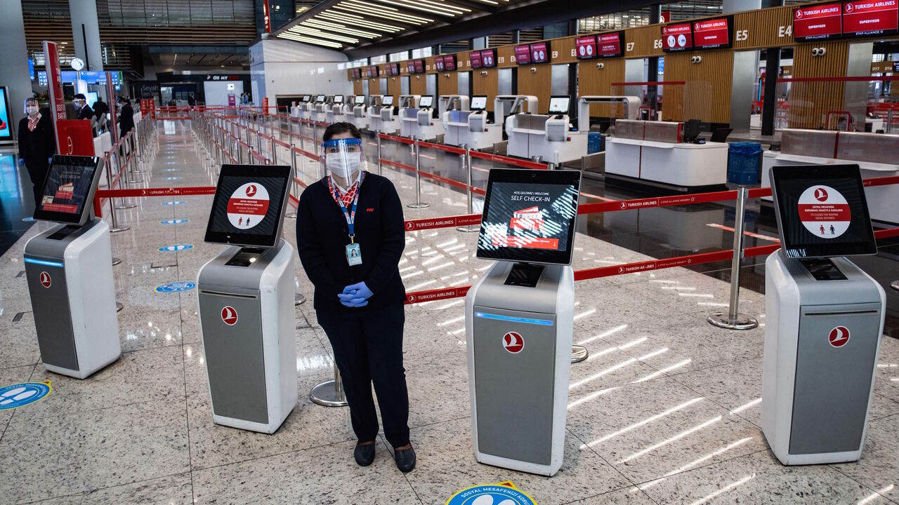 1216631279 Employees wearing protective face masks wait for passengers at the Istanbul Airport on the first day of the resumtion of domestic flights which were halted since March 26 due to the spread of the novel coronavirus, COVID-19, in Istanbul on June 1, 2020. (Photo by Yasin AKGUL / AFP) (Photo by YASIN AKGUL/AFP via Getty Images)