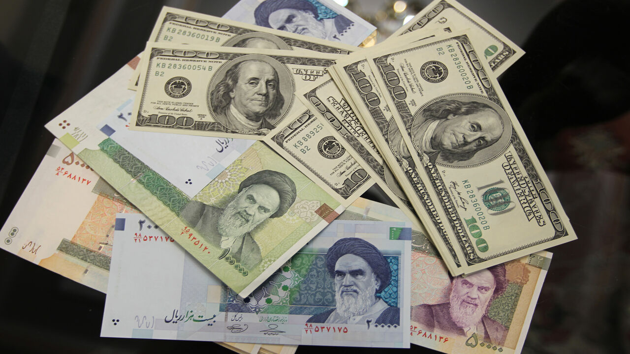 137267692 The picture illustrates United States 100-dollar bills bearing the portrait of US statesman, inventor and diplomat Benjamin Franklin next to Iran's various Rial banknotes, bearing a portrait of Iran's late founder of Islamic Republic Ayatollah Ruhollah Khomeini in Tehran on January 18, 2012. The Rial's plunge, to 18,000 to the dollar hit a record low on January 18, based on rates in black market trading that the government has tried to ban. AFP PHOTO/ATTA KENARE (Photo credit should read ATTA KENARE/AFP via