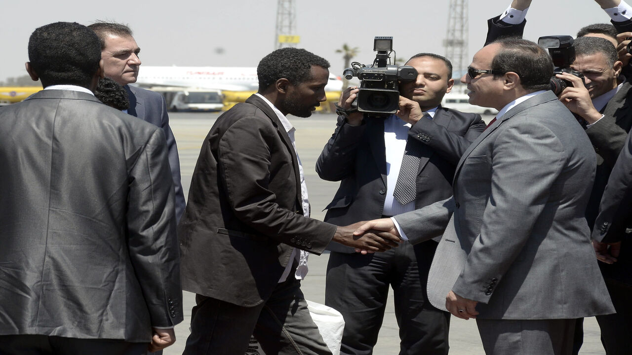 472427072 Egyptian President Abdel Fattah al-Sisi (R) receives an Ethiopian man who Sisi said was "rescued" from war-torn Libya alongside 26 of his compatriots by Egypts security services upon their arrival at Cairo airport on May 7, 2015. It was not immediately clear how the Ethiopians were rescued, but Sisi's office said the group flown in on an Egyptian plane was "liberated by Egyptian and Libyan security services". AFP PHOTO / STR (Photo credit should read STR/AFP via Getty Images)