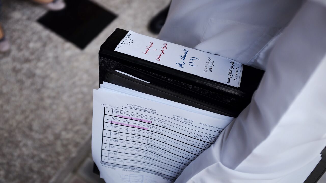 477298280 A Bahraini lawyer, S Mohsin Al-Alawi (R) holds the defence case file for Sheikh Ali Salman, head of the Shiite opposition movement Al-Wefaq, as he leaves the court after the sentence hearing on June 16, 2015, in Manama. A Bahrain court jailed Shiite opposition leader Salman for four years after convicting him of inciting disobedience and hatred in the Sunni-ruled kingdom, a judicial source said. AFP PHOTO / MOHAMMED AL-SHAIKH (Photo credit should read MOHAMMED AL-SHAIKH/AFP via Getty Images)