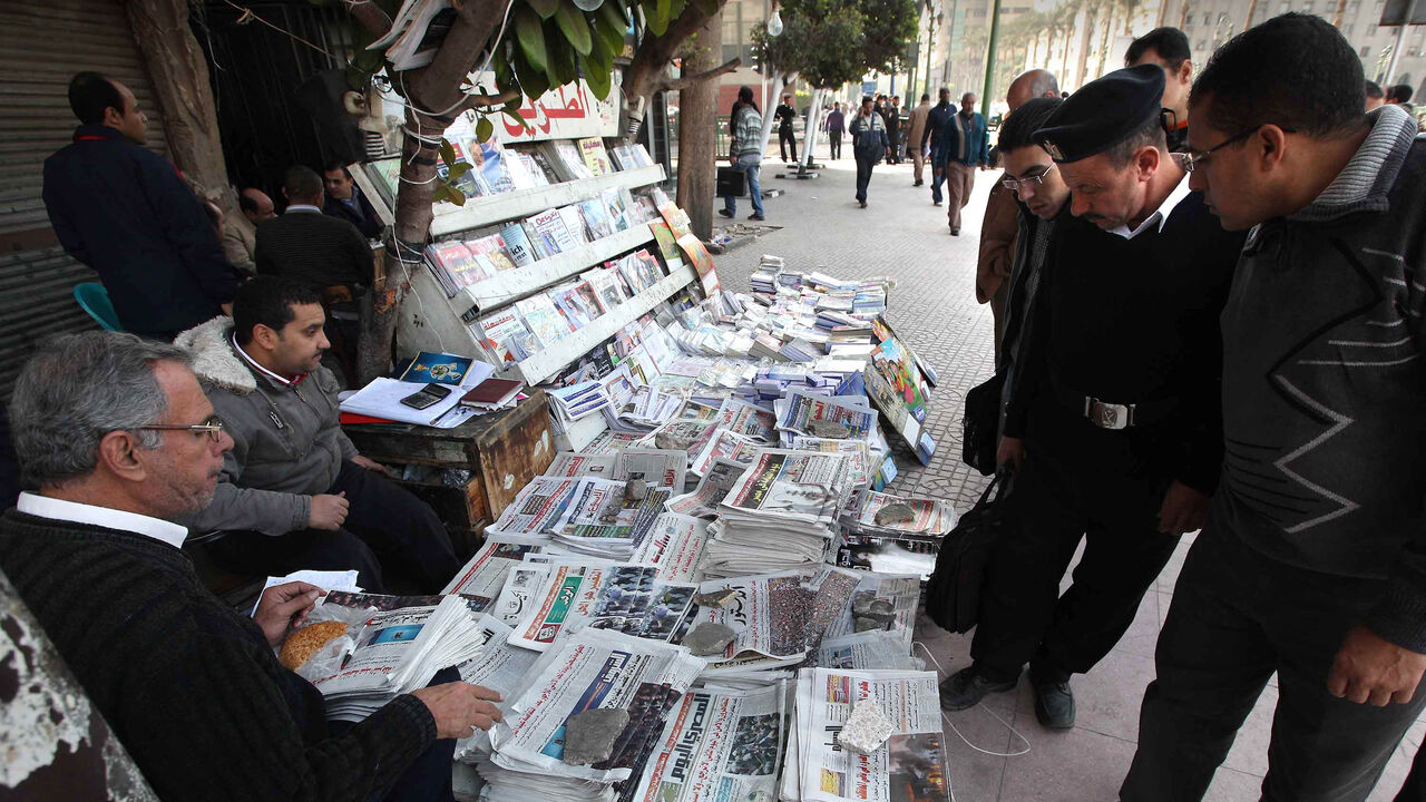 108426744 CAIRO, EGYPT - JANUARY 27: Locals look at newspapers carrying reports and pictures of street protests on January 27, 2011 in Cairo, Egypt. Thousands of police are on the streets of the capital and hundreds of arrests have been made in an attempt to quell anti-government demonstrations. (Photo by Peter Macdiarmid/Getty Images)