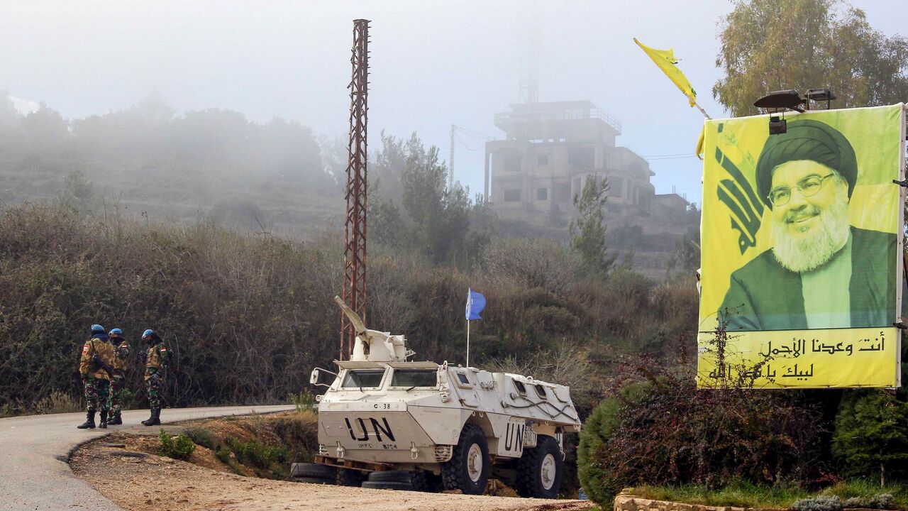 1191438524 A United Nations Interim Forces in Lebanon (UNIFIL) armoured vehicle is parked under a portrait of Hezbollah leader Hassan Nasrallah on a side road in the southern Lebanese town of Kfar Kila near the border with Israel on January 3, 2020. - Following this morning's killing of Iranian commander, Major General Qasem Soleimani, Lebanon's Iran-backed Hezbollah movement called for the missile strike by Israel's closest ally, to be avenged. "Meting out the appropriate punishment to these criminal assassins... wil