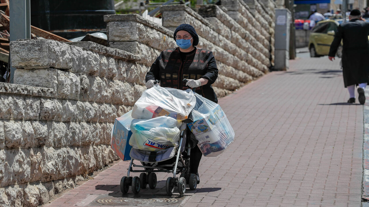 1209727198 An ultra-Orthodox Jewish woman wearing a protective face mask, returns from shopping in Jerusalem's neighbourhood of Mea Shearim, on April 12, 2020, during the novel coronavirus pandemic crisis. (Photo by AHMAD GHARABLI / AFP) (Photo by AHMAD GHARABLI/AFP via Getty Images)