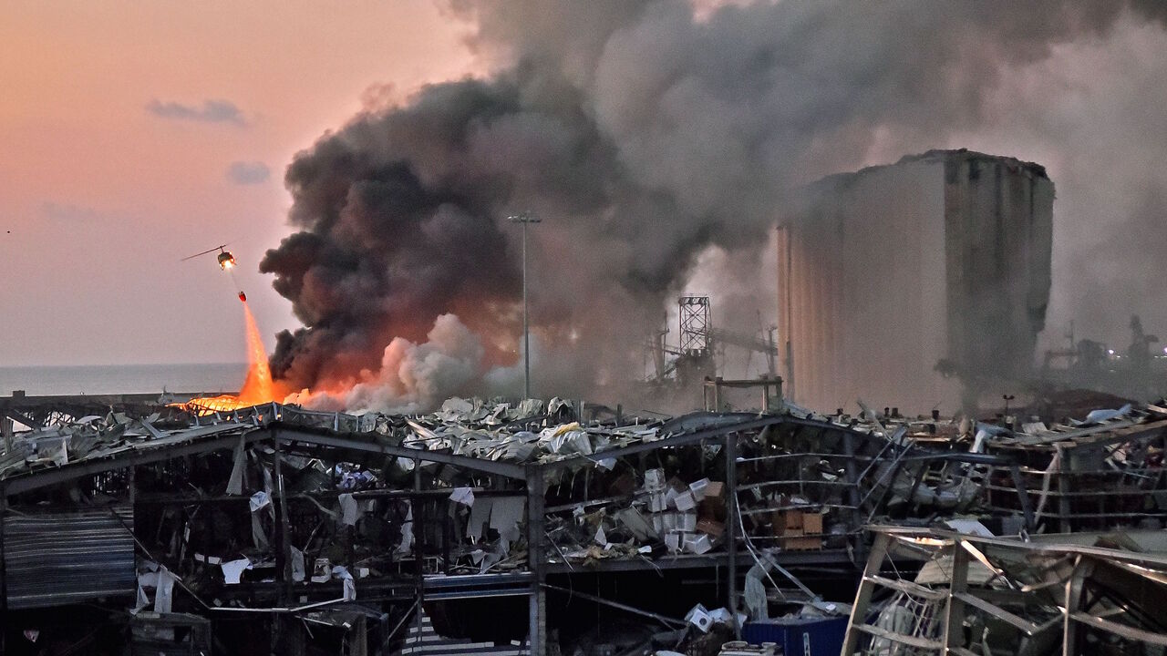 1227910234 TOPSHOT - EDITORS NOTE: Graphic content / A helicopter puts out a fire at the scene of an explosion at the port of Lebanon's capital Beirut on August 4, 2020. (Photo by STR / AFP) (Photo by STR/AFP via Getty Images)