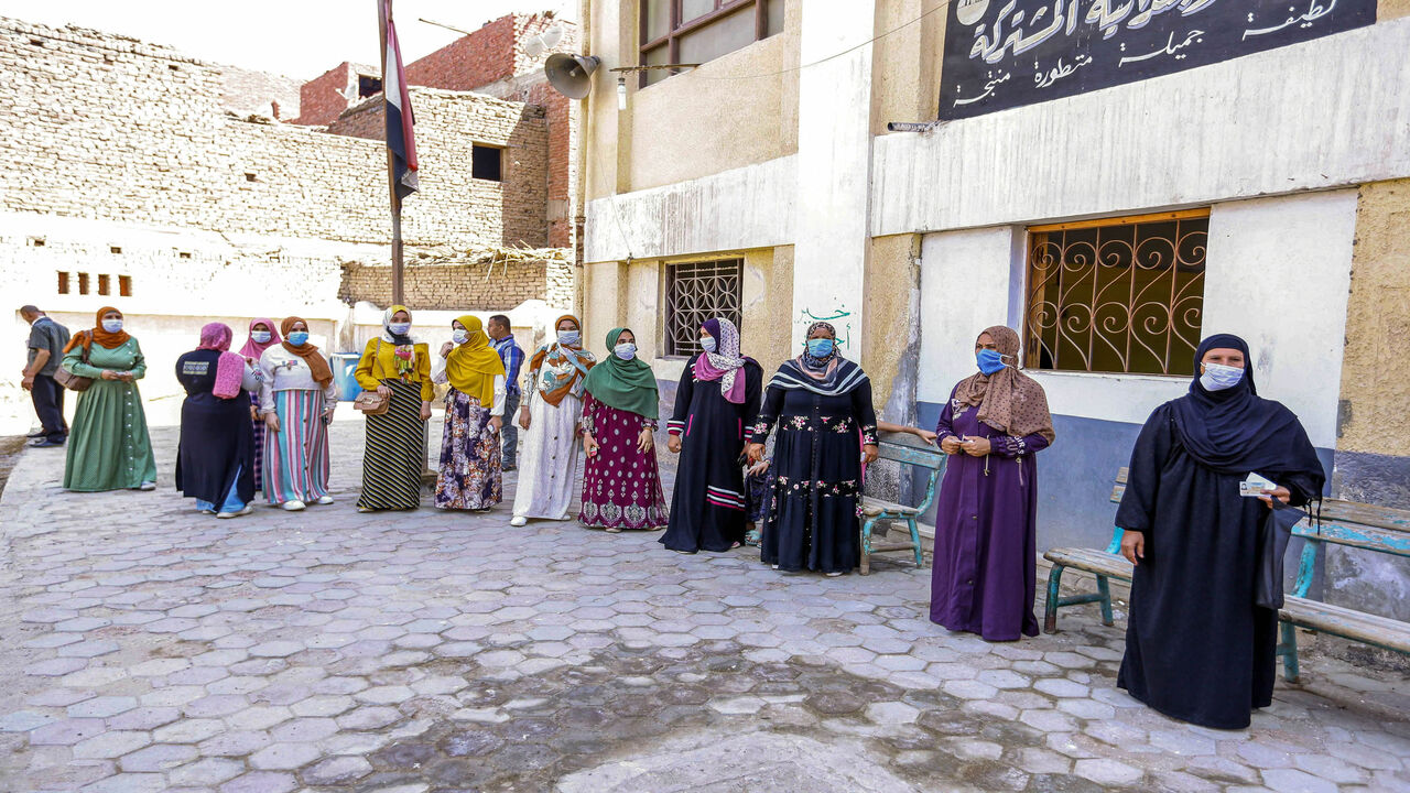 1228001307 Women, mask-clad due to the COVID-19 coronavirus pandemic, wait to cast their ballots outside a polling station in the town of el-Ayyat in Giza province south of the Egyptian capital on August 11, 2020 for candidates running in the upper house election for the newly created Senate. - The two-day vote for 200 of the Senate's 300 seats will be largely contested by candidates who back President Abdel Fattah al-Sisi, who has quietened most opposition within and outside the legislature. (Photo by - / AFP) (Photo