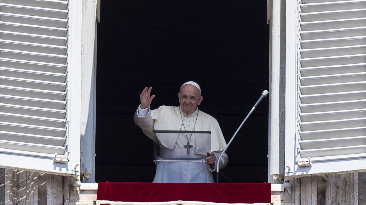 1228053101 Pope Francis waves at faithfuls from the window of the apostolic palace overlooking St.Peter's square during his Angelus prayer on August 15, 2020 at the Vatican. (Photo by Tiziana FABI / AFP) (Photo by TIZIANA FABI/AFP via Getty Images)