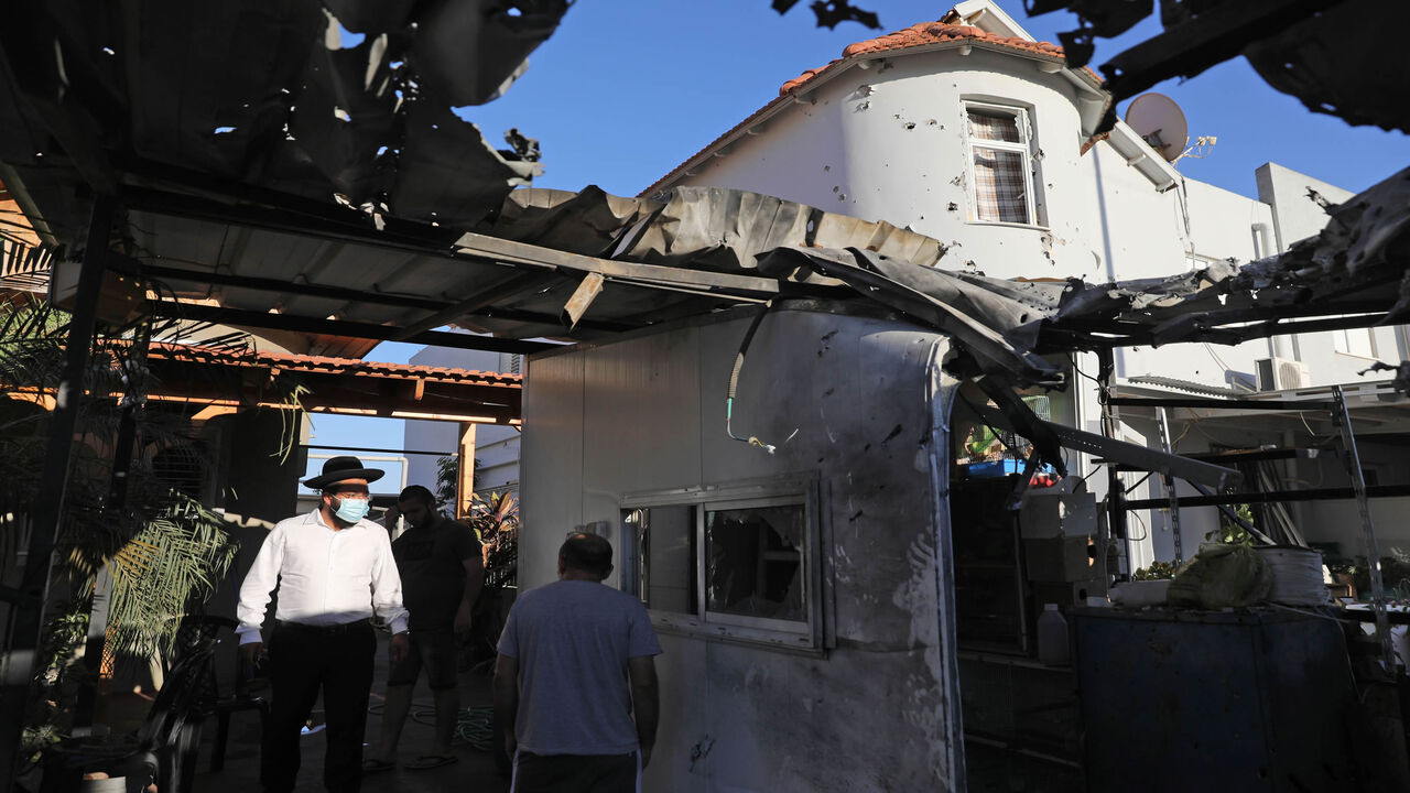 1228069484 People inspect the damages at a house that was hit by a rocket launched from Gaza to the southern Israeli city of Sderot, early morning on August 16, 2020. (Photo by Menahem KAHANA / AFP) (Photo by MENAHEM KAHANA/AFP via Getty Images)