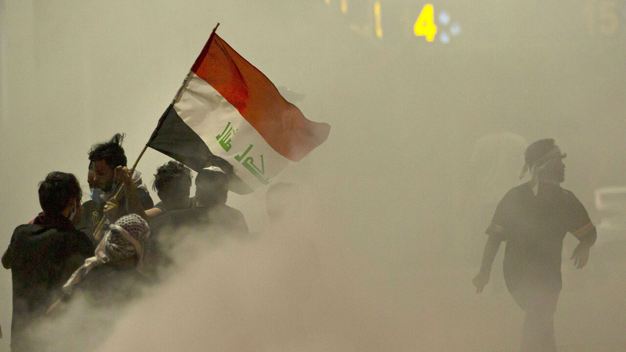 1228083635 TOPSHOT - Iraqi demonstrators gather amid smoke after fire services extinguished fire on tires during a protest near the governor's residence in the southern city of Basra, to oppose assassinations and demand the resignation of top security officials in the southern Iraqi governorate, on August 17, 2020. (Photo by Hussein FALEH / AFP) (Photo by HUSSEIN FALEH/AFP via Getty Images)