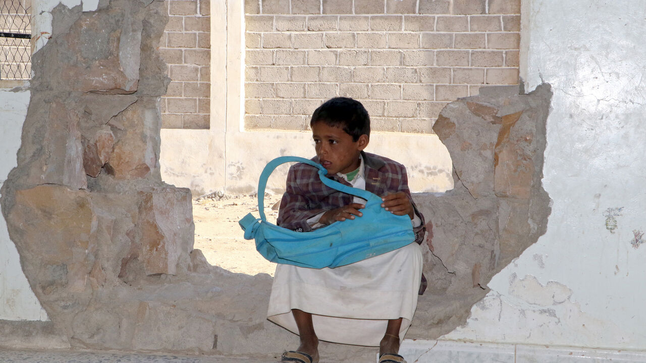 YEMEN-CONFLICT-CHILDREN-EDUCATION-SCHOOL A Yemeni boy sits in a hole in a wall at a school that was damaged in the country's ongoing conflict between the Saudi-led Arab coalition fighting Shiite Huthi rebels in the northern province of Saada, on March 14, 2017.
The conflict in Yemen, which escalated with the intervention of the Saudi-led coalition two years ago, has more than doubled the number of children deprived of schooling to some 3.5 million, threatening the future of a whole generation in the impoverished country. / AFP PHOTO / STRINGER / T