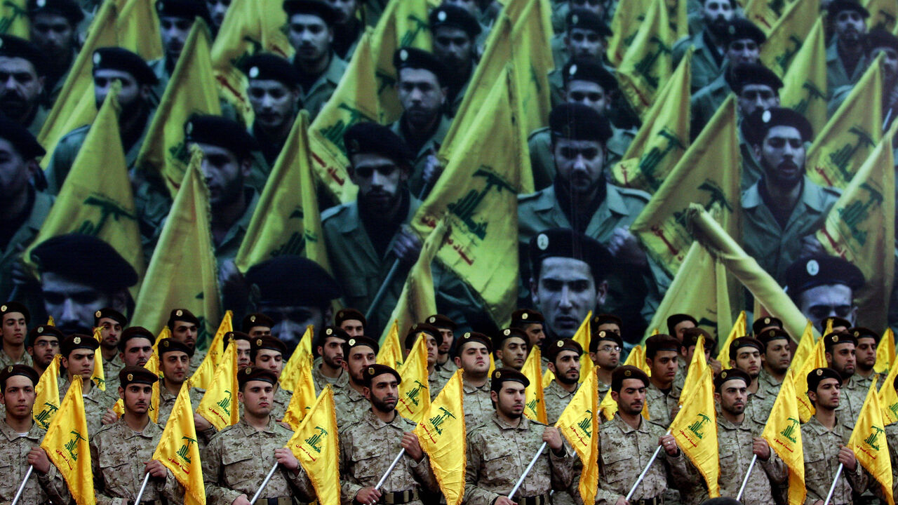 79952586 Shiite Muslims Hezbollah militants stand to attention as hundreds of people gather in a huge hall waiting to watch a televised speech by Hassan Nasrallah, the leader of the Shiite Muslim Lebanese Hezbollah militant group on February 22, 2008, in Beirut's southern suburb, ten days after the assassination of Hezbollah commander Imad Mughnieh in a bomb attack in Damascus. Nasrallah's televised speech marked the killing of Mughnieh and the 1992 assassination of its former leader Abbas Mussawi in an Israeli heli