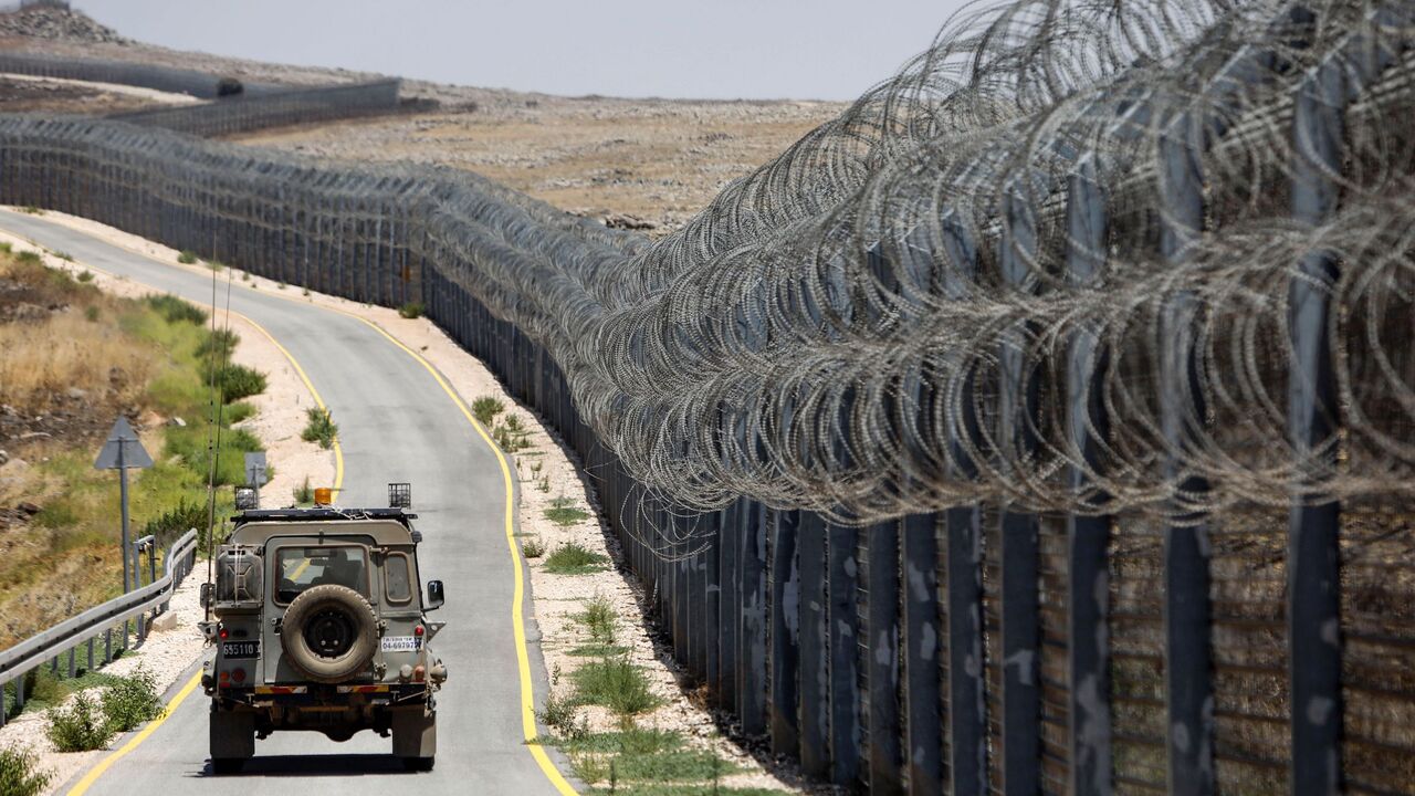 818822564 An Israeli army vehicle is seen driving along the road parallel to the border fence separating the Israeli-annexed Golan Heights and Syria, on July 19, 2017.
Israel is planning for a new field hospital to treat patients from the civil-war hit country, on the Syrian side of the fence but on the Israeli side of the demarcation line in the Golan Heights which it occupied in 1967, its military said on July 19, 2017.
/ AFP PHOTO / MENAHEM KAHANA (Photo credit should read MENAHEM KAHANA/AFP via Getty Imag