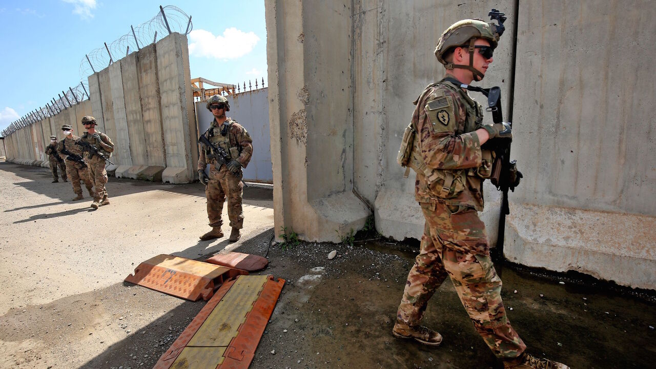 1208510241 US army soldiers, part of the Combined Joint Task Force Operation Inherent Resolve (CJTF-OIR) the US-led coalition against the Islamic State (IS) group, walk around at the K1 Air Base northwest of Kirkuk in northern Iraq before a planned US pullout on March 29, 2020. (Photo by AHMAD AL-RUBAYE / AFP) (Photo by AHMAD AL-RUBAYE/AFP via Getty Images)