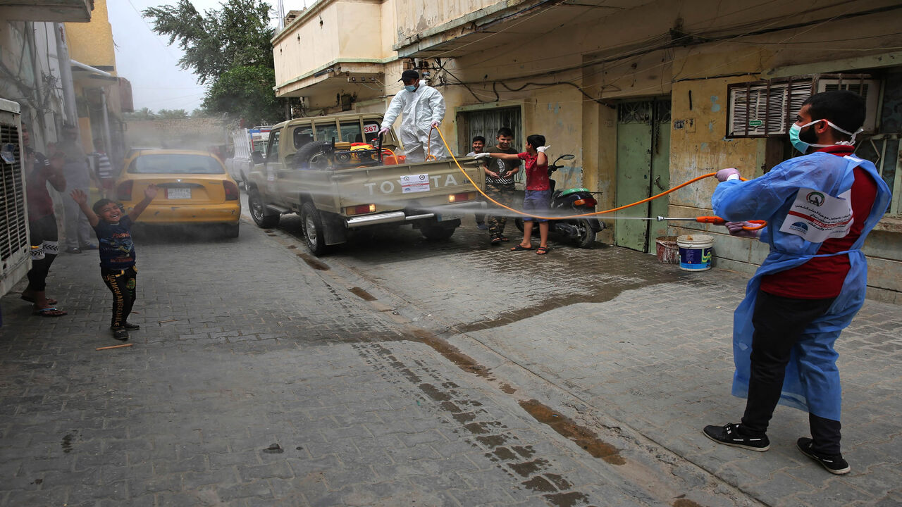 1209294275 Members of the Hashed al-Shaabi (Popular Mobilisation) forces militia disinfect a street in the western Washash district of the Iraqi capital Baghdad on April 6, 2020, as part of measures against the COVID-19 coronavirus pandemic. (Photo by AHMAD AL-RUBAYE / AFP) (Photo by AHMAD AL-RUBAYE/AFP via Getty Images)