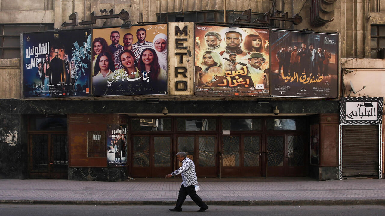 1214818174 This picture taken early on May 24, 2020 shows a view of the historic Metro cinema theatre as a man walks past, along the commercial Talaat Harb street in the almost deserted city centre Egypt's capital Cairo, on the first day of Eid al-Fitr, the Muslim holiday which starts at the conclusion of the holy fasting month of Ramadan. - Egypt had previously announced a lengthening of its night-time curfew and other measures to prevent large gatherings during the Eid al-Fitr holidays. One of the most important dat