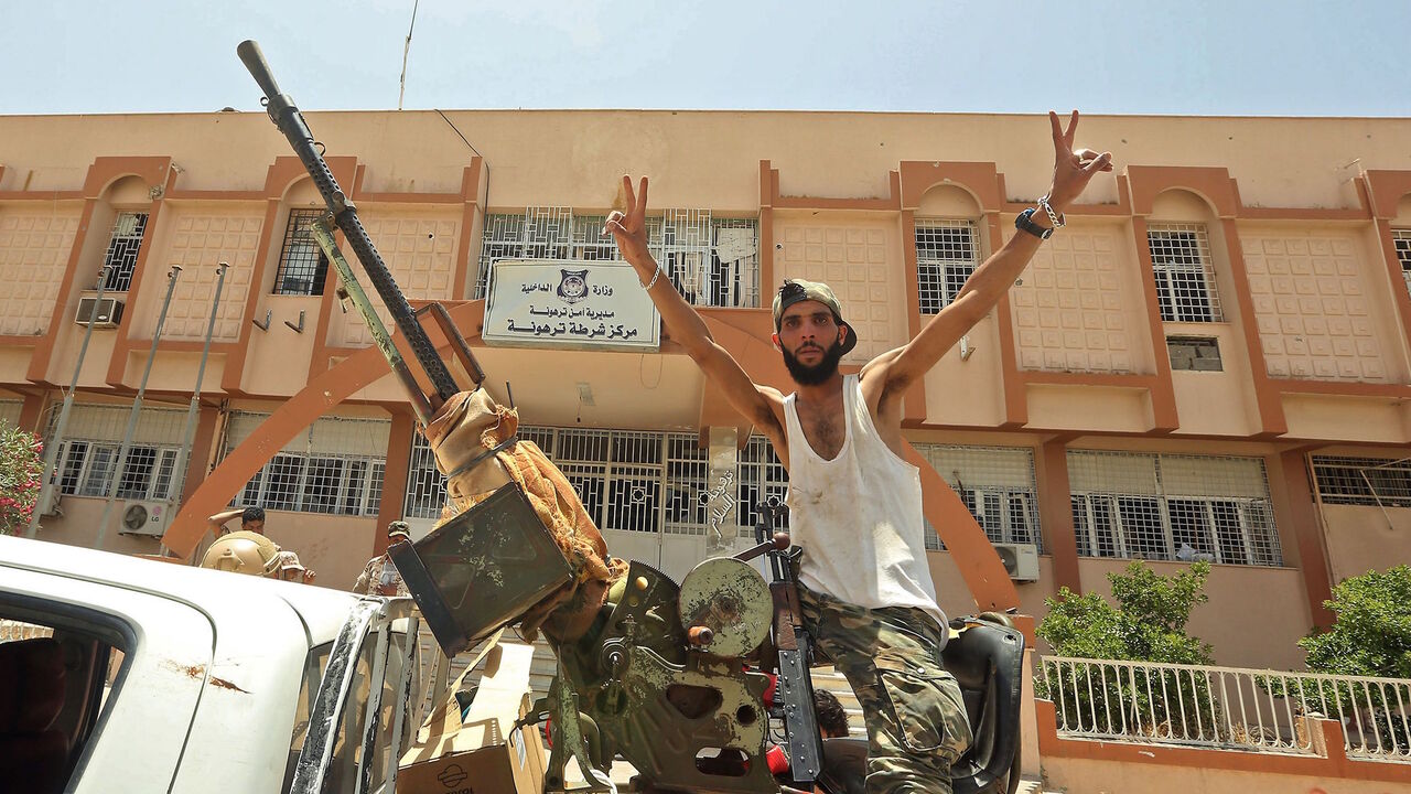 1217771868 A fighter loyal to Libya's UN-recognised Government of National Accord (GNA) poses for a picture while seated in the turret a technical (pickup truck mounted with turret) in the town of Tarhuna, about 65 kilometres southeast of the capital Tripoli on June 5, 2020, after the area was taken over by pro-GNA forces from rival forces loyal to strongman Khalifa Haftar. - The GNA said on June 5 that it was back in full control of Tarhouna, the last stronghold of the forces of eastern strongman Khalifa Haftar. The