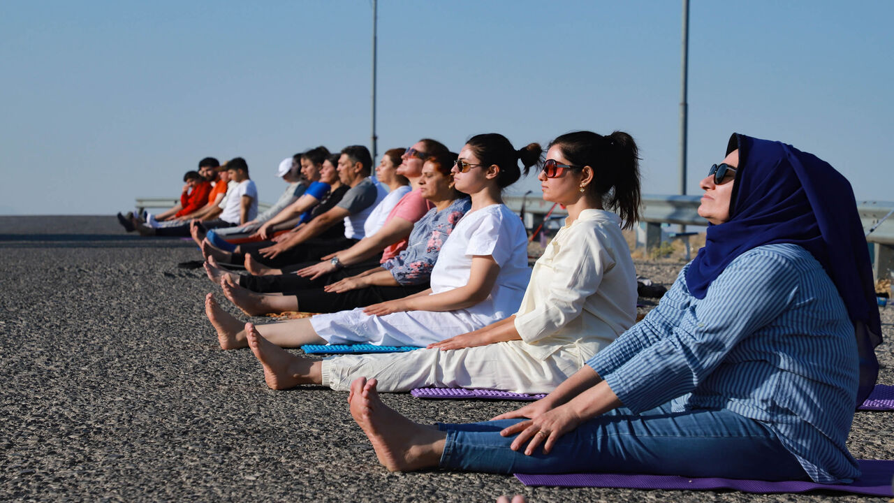 1227690846 Kurdish Iraqi men and women practice yoga on Mount Azmar, which overlooks the northern city of Sulaimaniyah in Iraq's autonomous Kurdish region, on July 19, 2020. - According to kurdish Iraqi Yoga instructor Muhammad Sherzade, an increasing number of people joined his class since he established his school in the region in 2016, following the outbreak earlier this year of the coronavirus epidemic. (Photo by Shwan MOHAMMED / AFP) (Photo by SHWAN MOHAMMED/AFP via Getty Images)