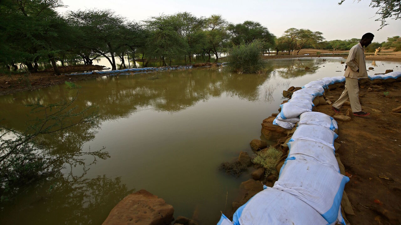 1228439597 A worker with the Sudanese antiquities authority lines a stone wall with sandbags to mitigate flood water damage to a structure in the ancient royal city at the archaeological site of Meroe, in the River Nile State's al-Bajrawia area, 200Km north of the capital, on September 9, 2020. - The ancient complex of Meroe, capital of the powerful Meroitic Empire lasting from 350 BCE to 350 CE, extends over 1500 Km in the Nile valley. It is composed of the necropolis of Kushite royalty with its renowned pyramids, as