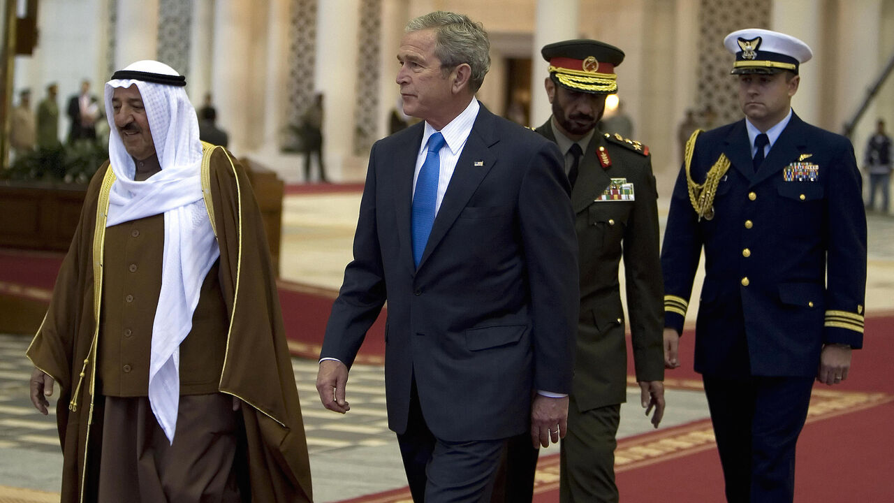 78905171 US President George W. Bush (C) and Emir of Kuwait Sheikh Sabah al-Ahmad al-Sabah (L) walk together during the arrival ceremony of the former at Kuwait International Airport in Kuwait City, 11 January 2008. US President George W. Bush arrived in Kuwait today to rally the support of Arab allies against what he calls the Iranian "threat," after making a bold prediction for Middle East peace. AFP PHOTO/JIM WATSON (Photo credit should read JIM WATSON/AFP via Getty Images)